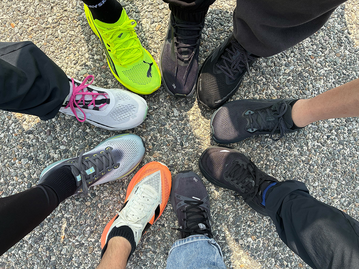 ランニングシューズを合わせた足元の写真。黒とカラフルな靴が半分ずつ